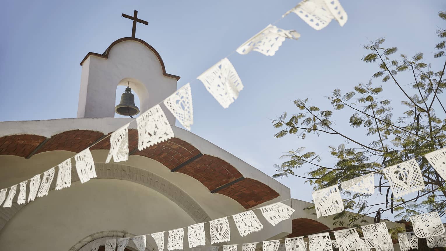 White Mexican wedding banners strung below church in Sayulita