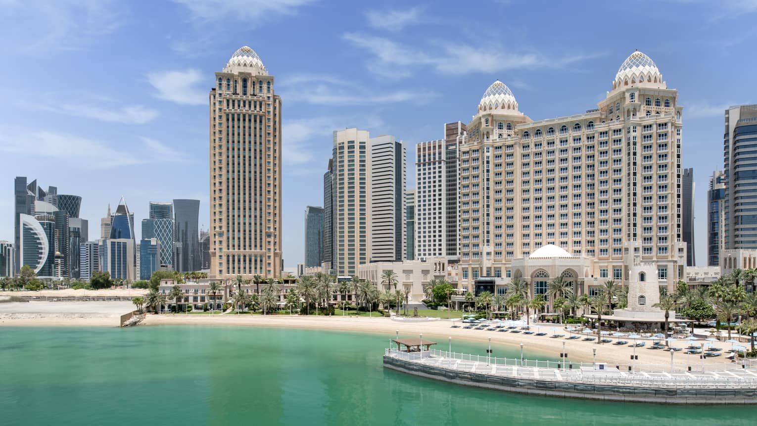 A large building next to water and a pier.