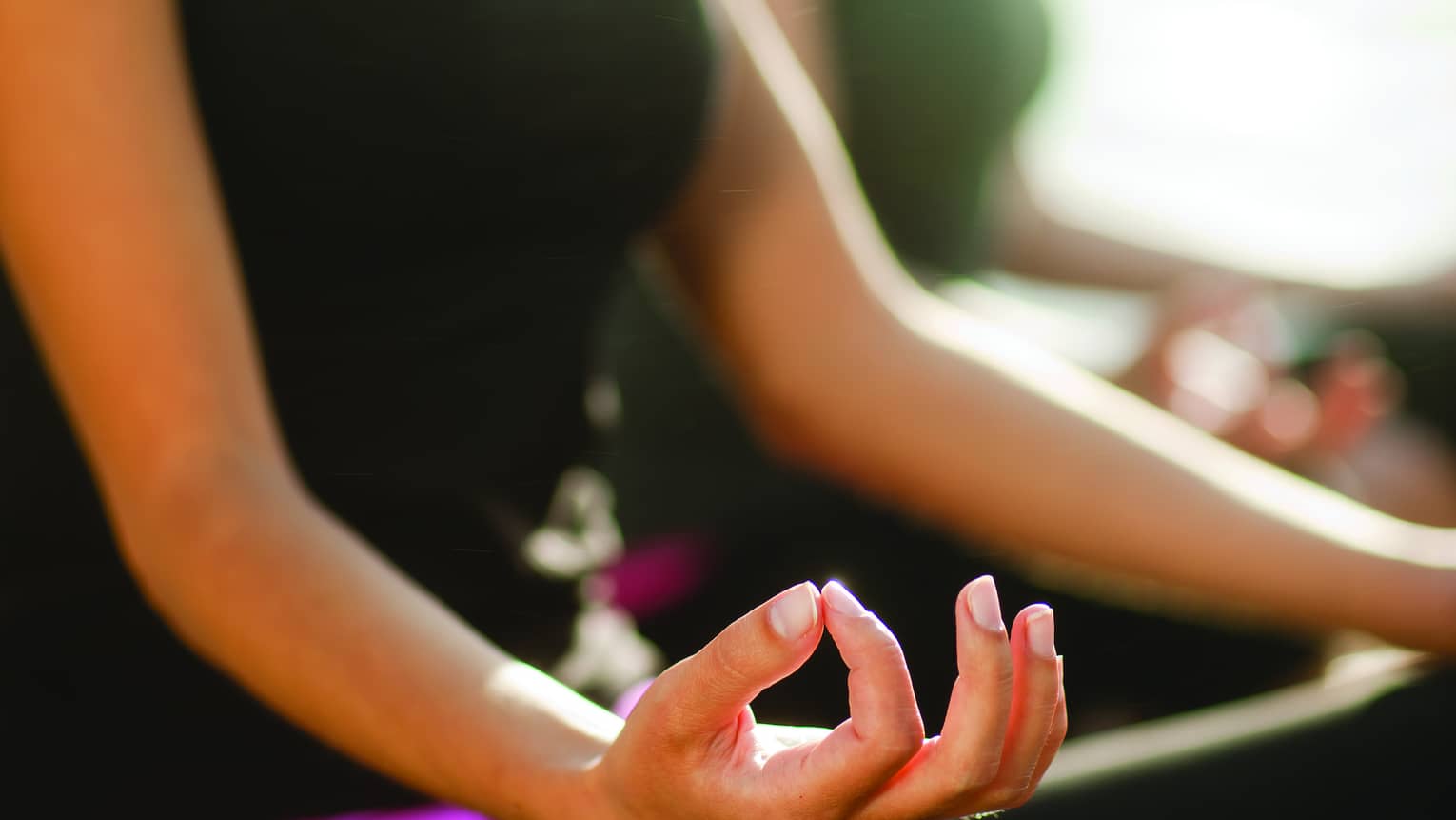 Two women sitting in a yoga pose.