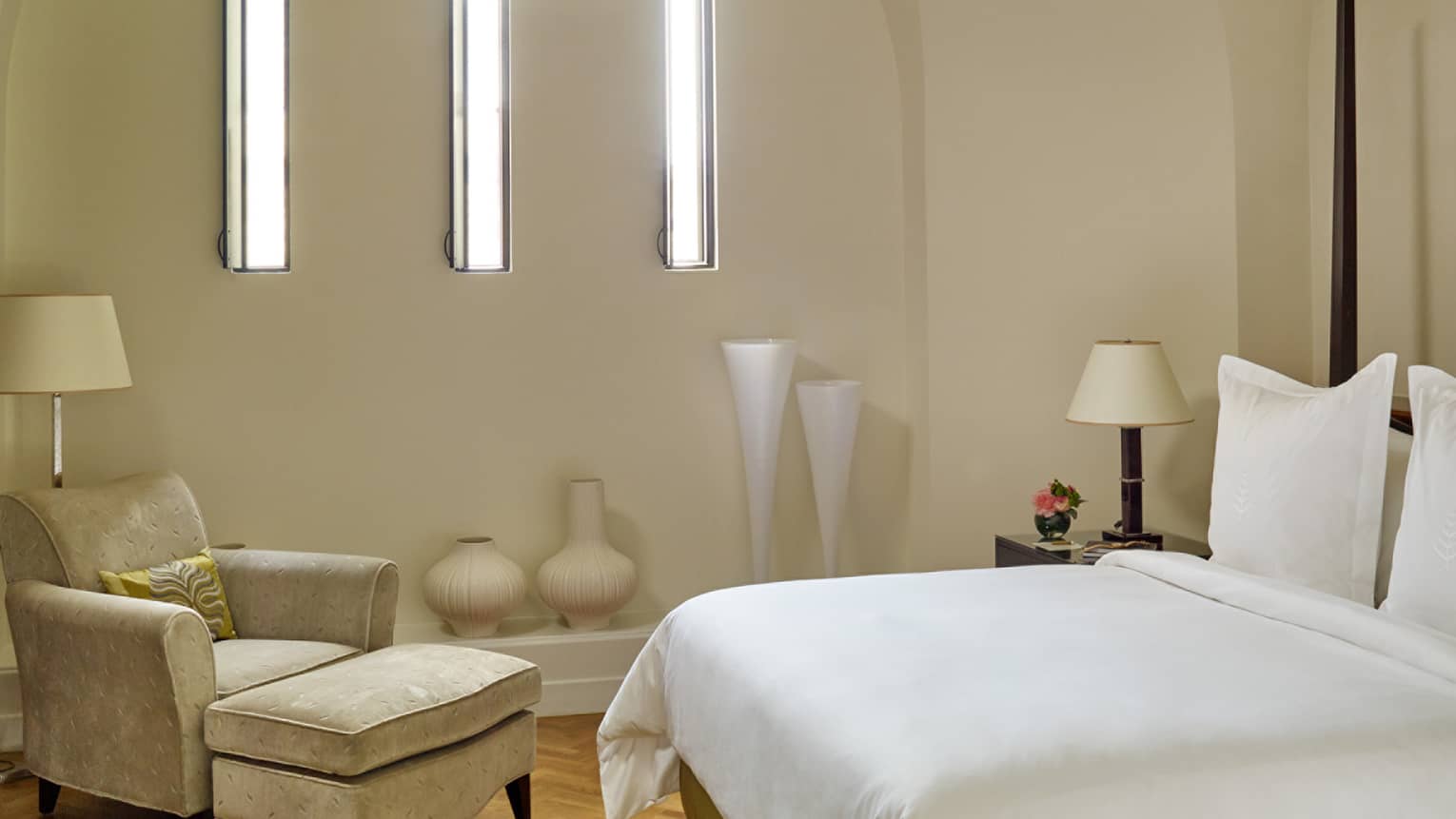 Tower Suite bed with ivory armchair, vertical lights on wall