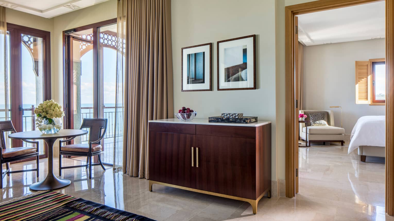 Four Seasons Sea-View Suite wood vanity with bowl of plums, small dining table by sunny window
