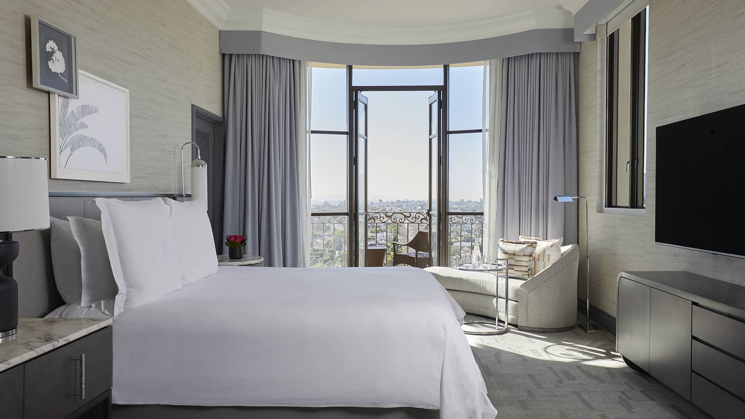 Bedroom with king bed and city-view balcony