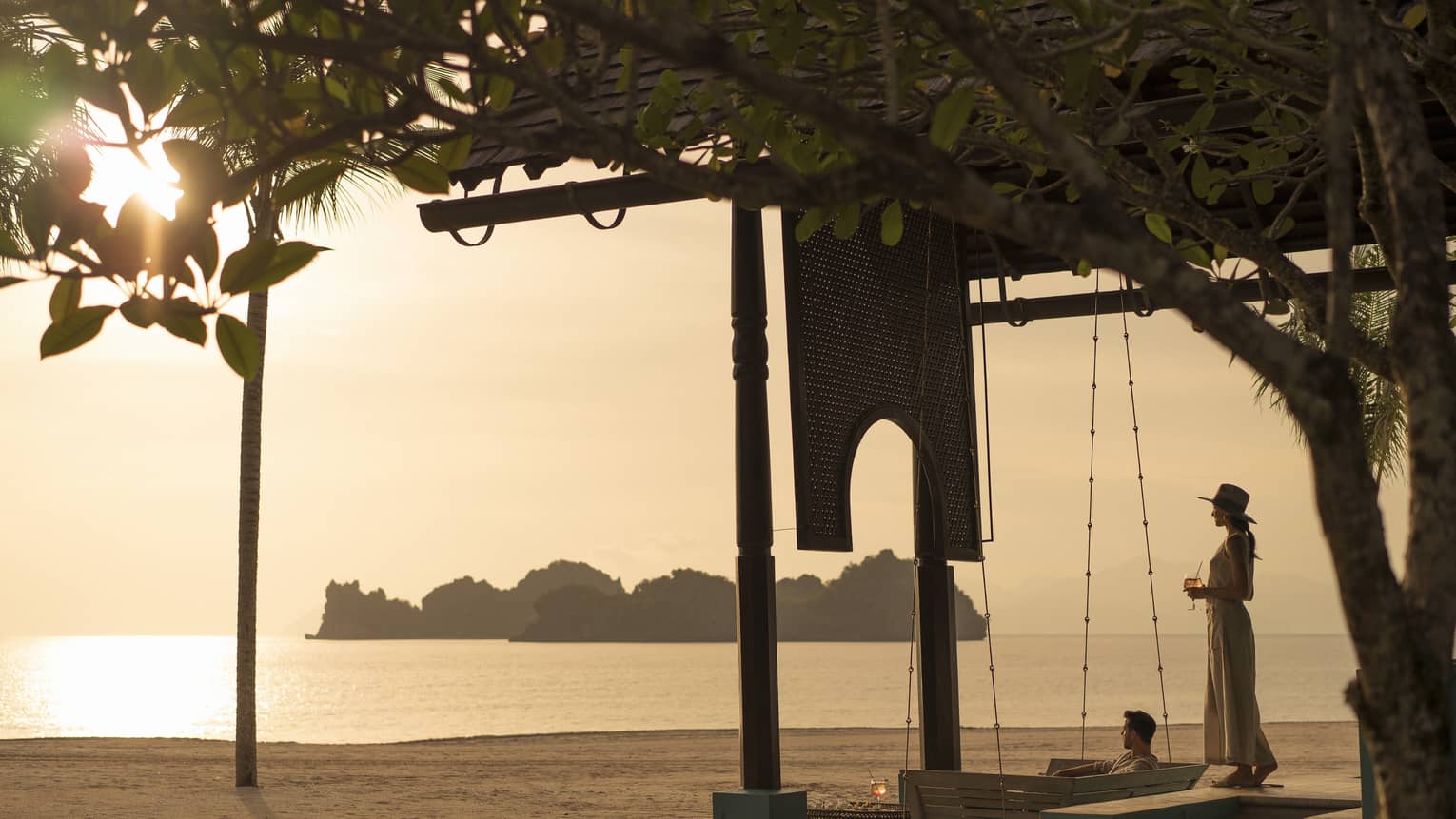 A woman overlooks the water on the beach at Rhu Bar