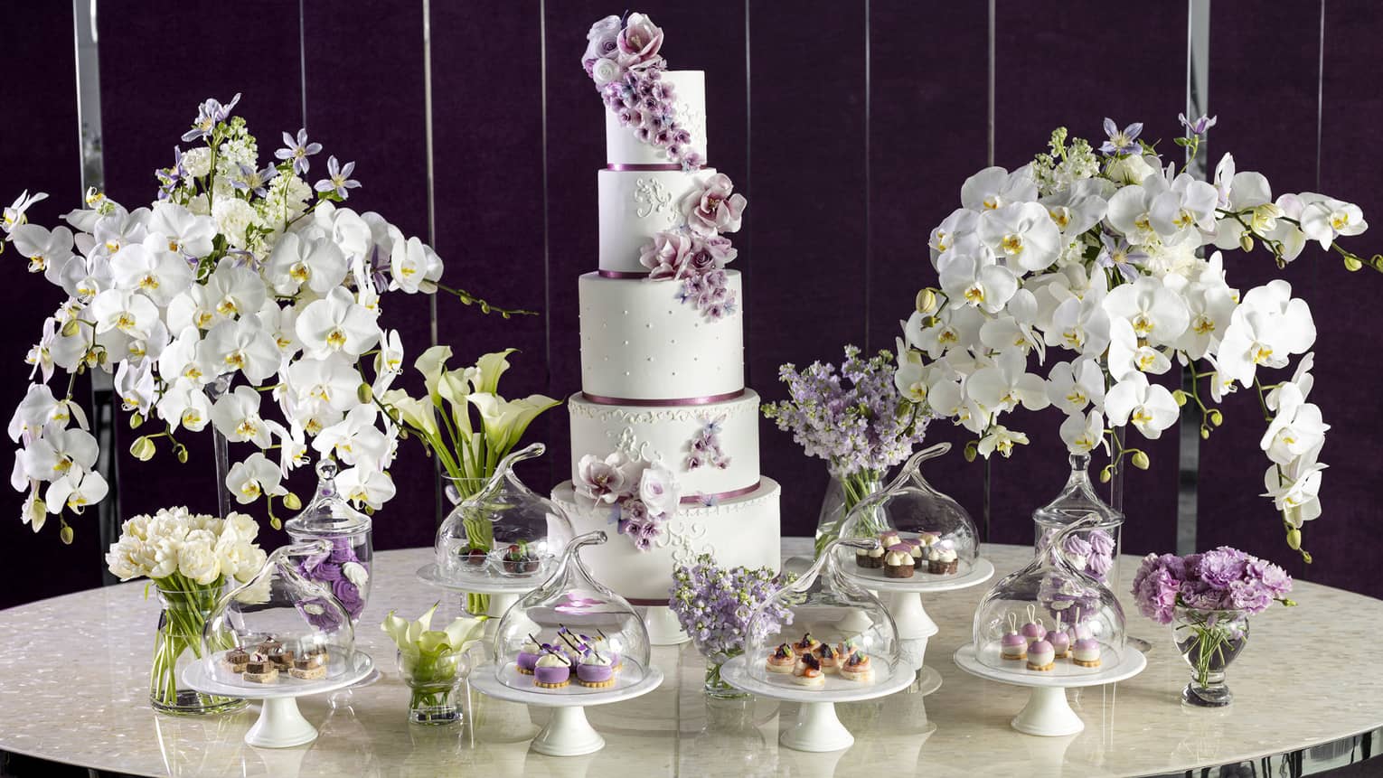 Wedding cake and cupcake display with white orchids