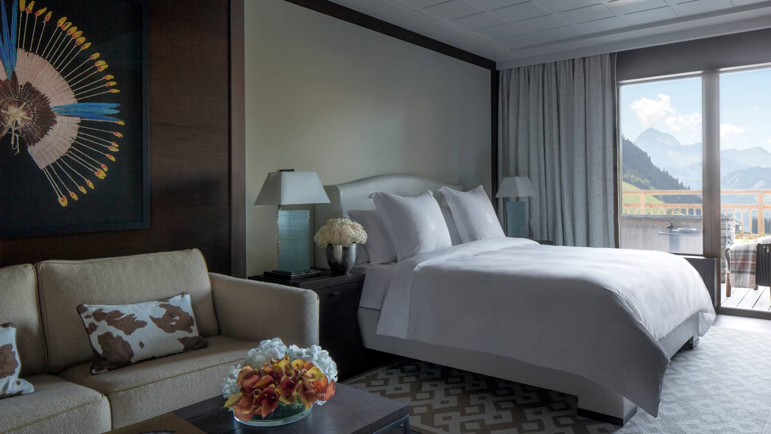 Deluxe One-Bedroom Suite bed with white linens by large window