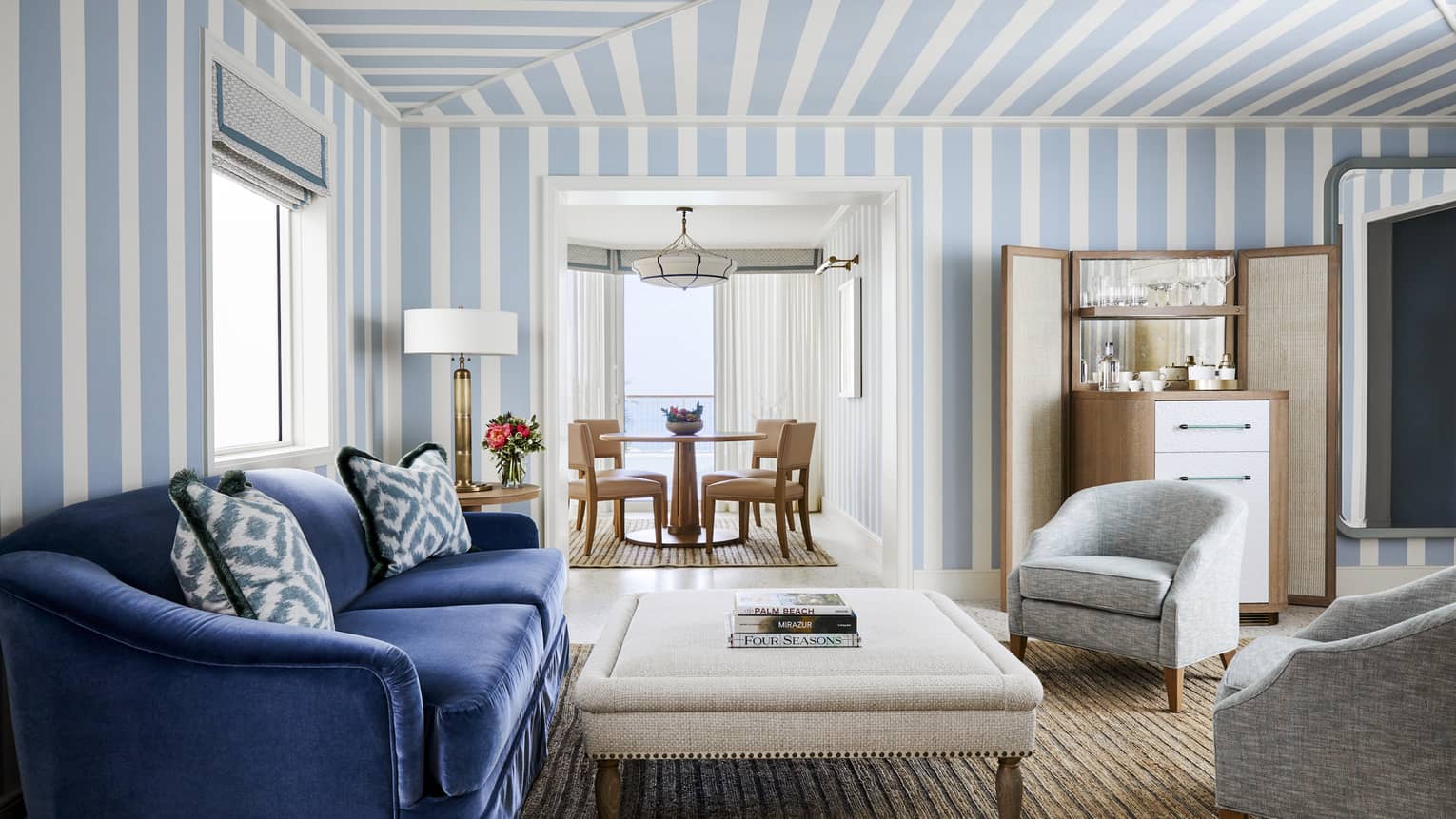 Blue and white striped wallpaper accents a living room with comfortable furniture