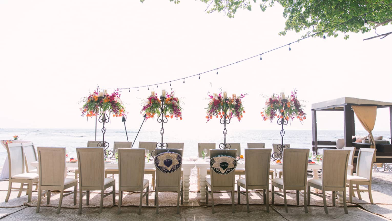 Chairs line sunny outdoor patio dining table with floral arrangements