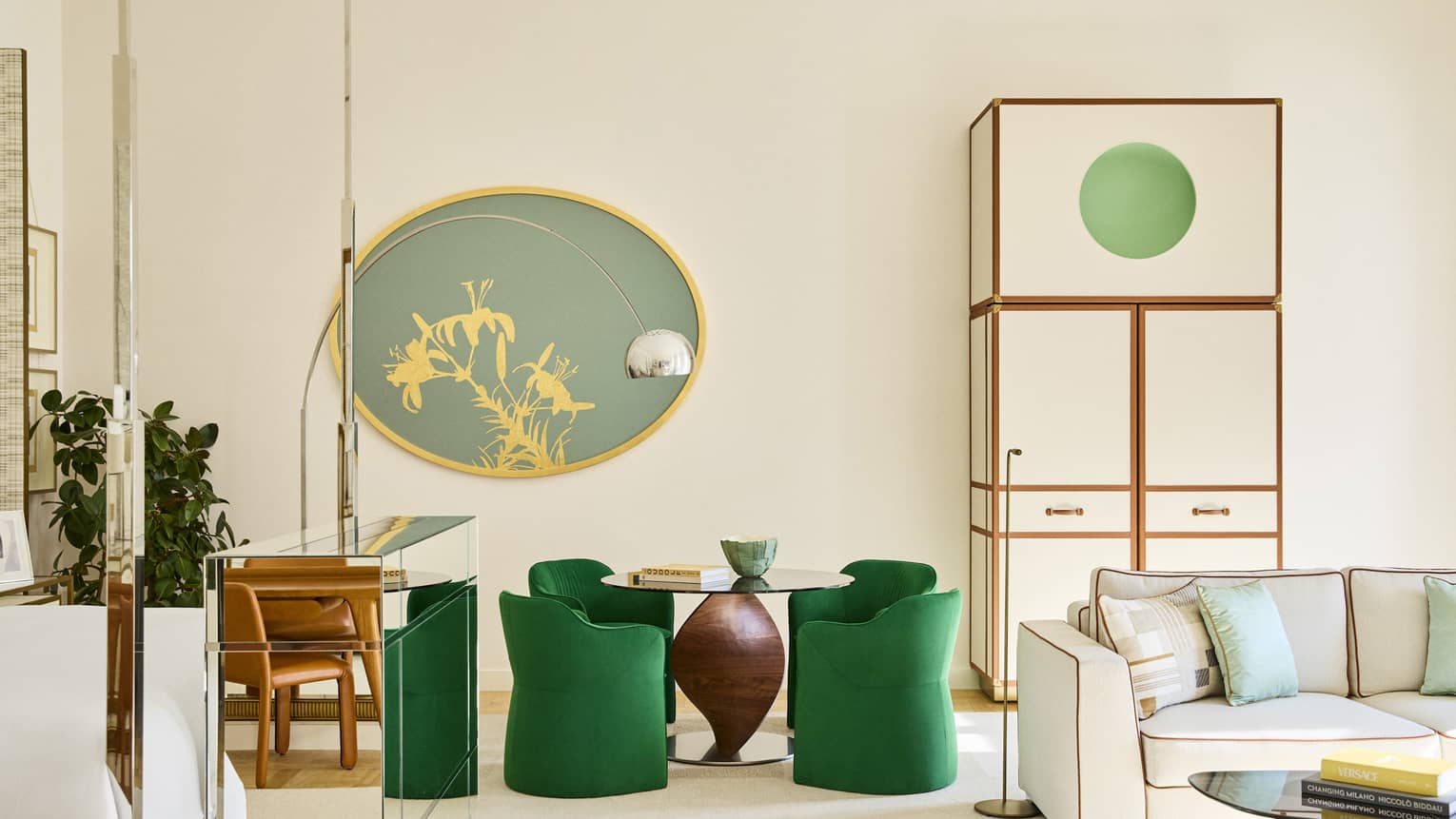 Modern hotel suite featuring a dining table and four green chairs