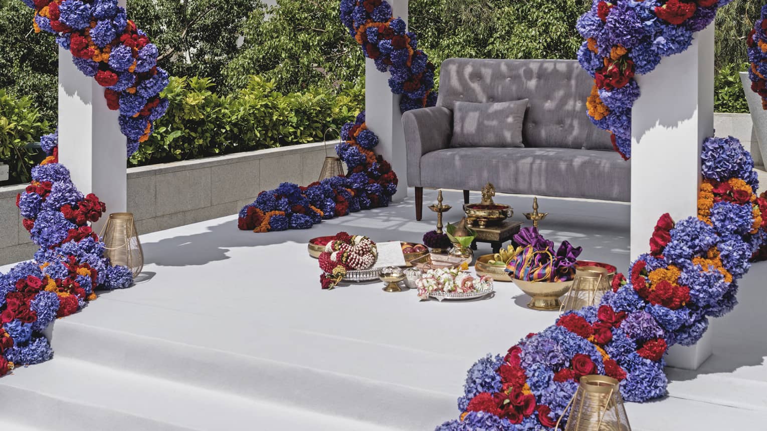 Wedding ceremony under altar with large purple, red and orange floral garlands