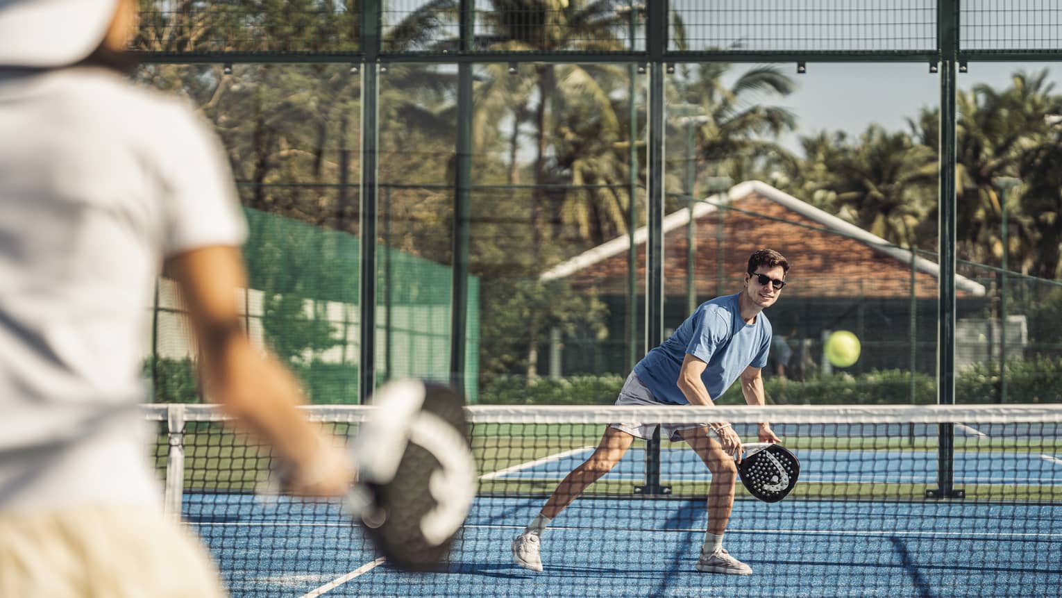 Couple plays paddleball on artificial turf court