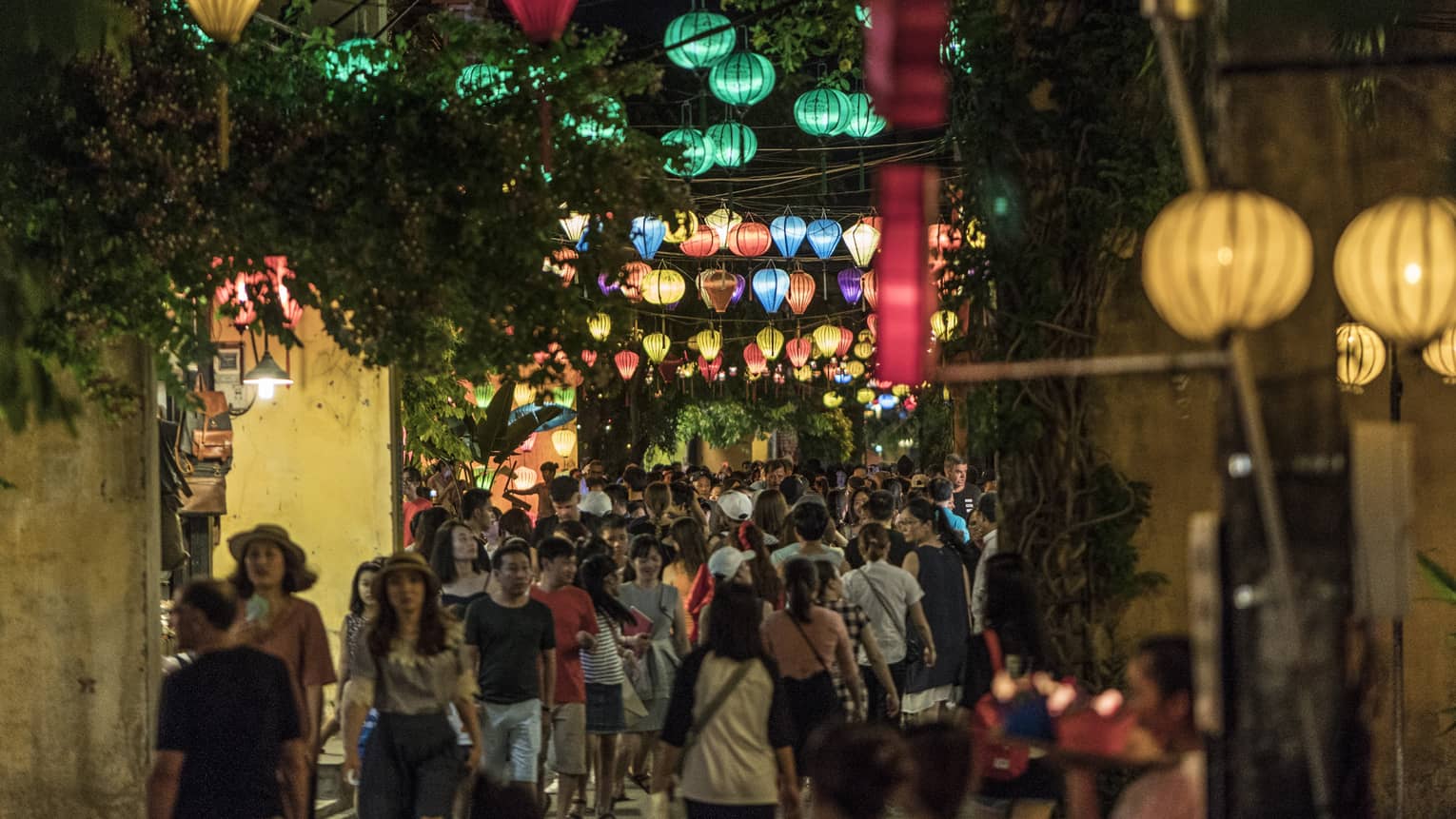 A nighttime view of a crowded street at night, lit with colorful lanterns in Hoi, Viet Nam