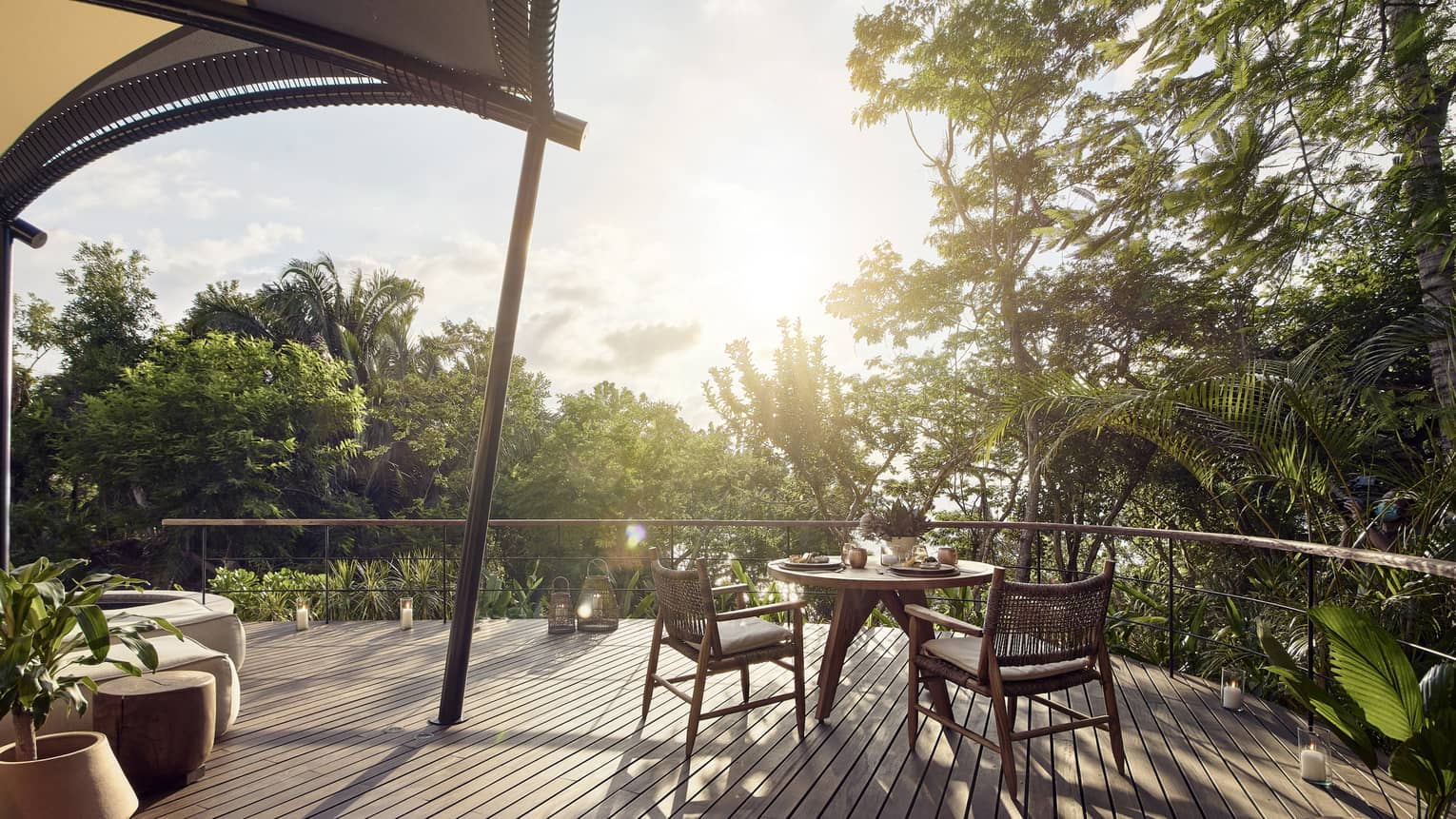 Wooden deck with dining table for two, surrounded by trees