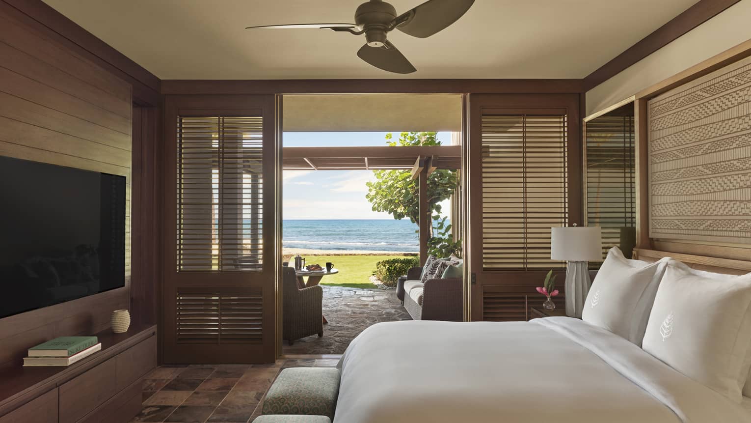 Bedroom with natural Hawaiian finishes, walk-out terrace with beach view