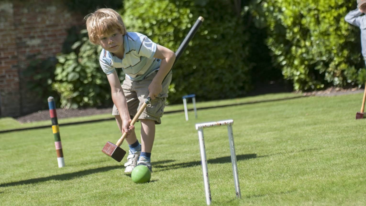 Two young boys and a father playing cricket.