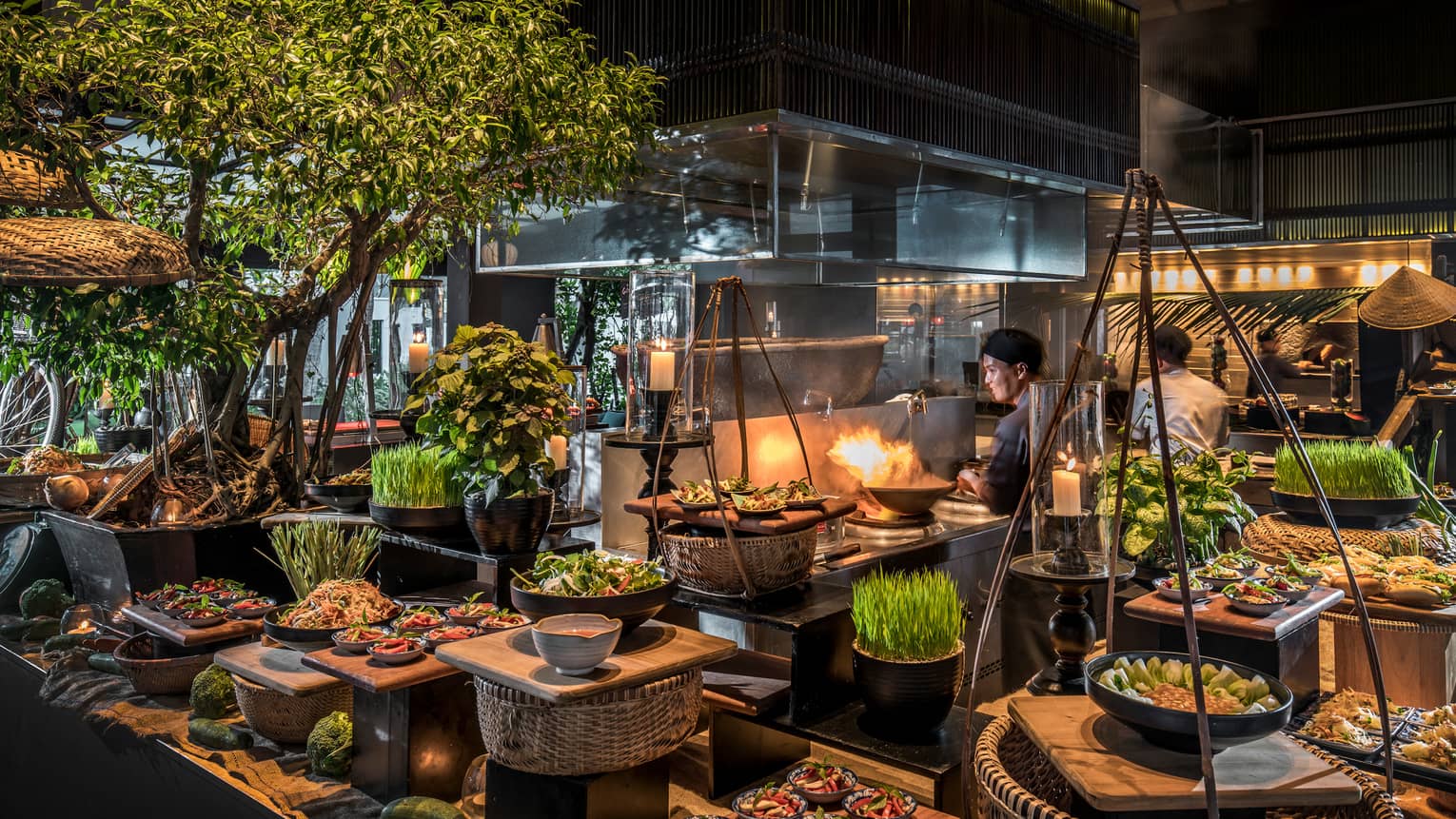 Chefs toss woks, flames around stoves, baskets of produce at The Nam Hai Cooking Academy