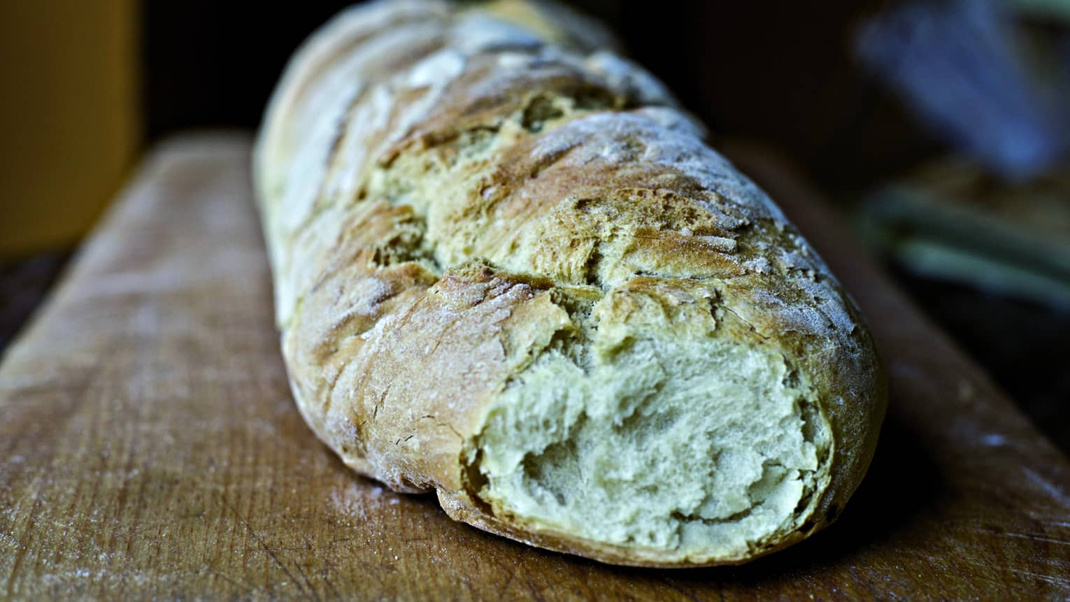 Rustic loaf of bread on wood board