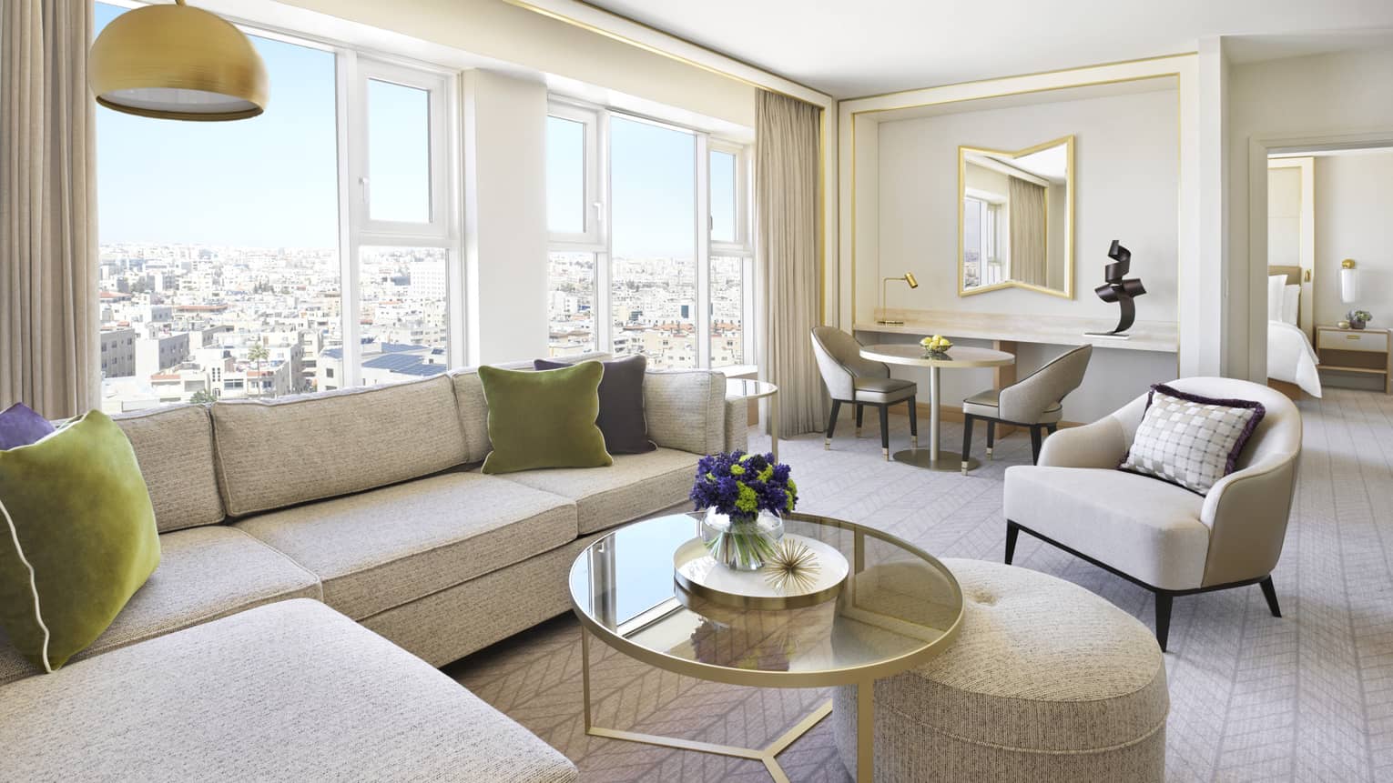 A small parlour with an L-shaped couch, and several tables and chairs to sit in all overlooking the city. 