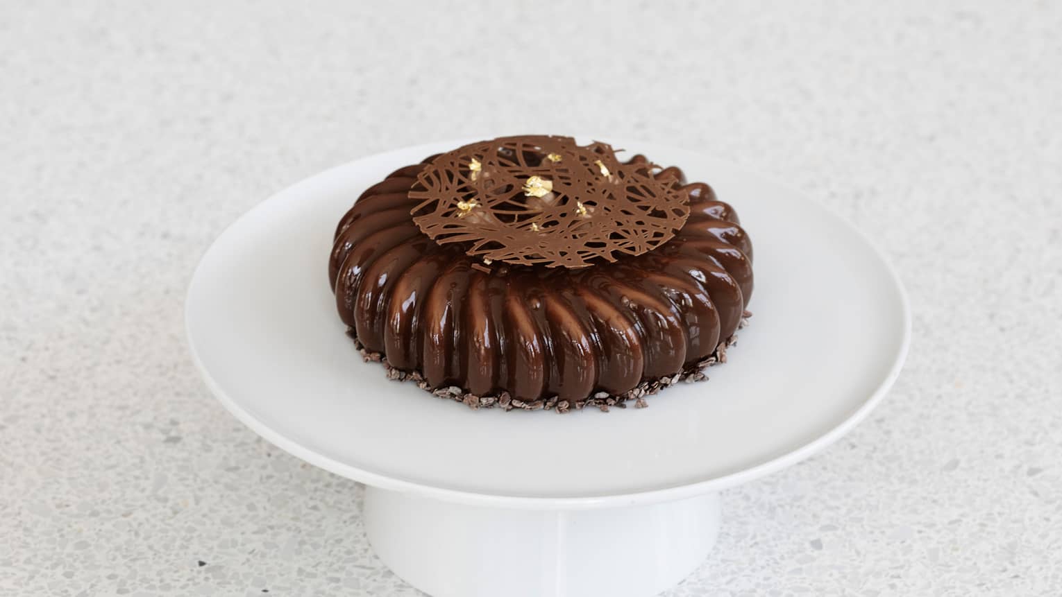 A chocolate cake on a white tray.