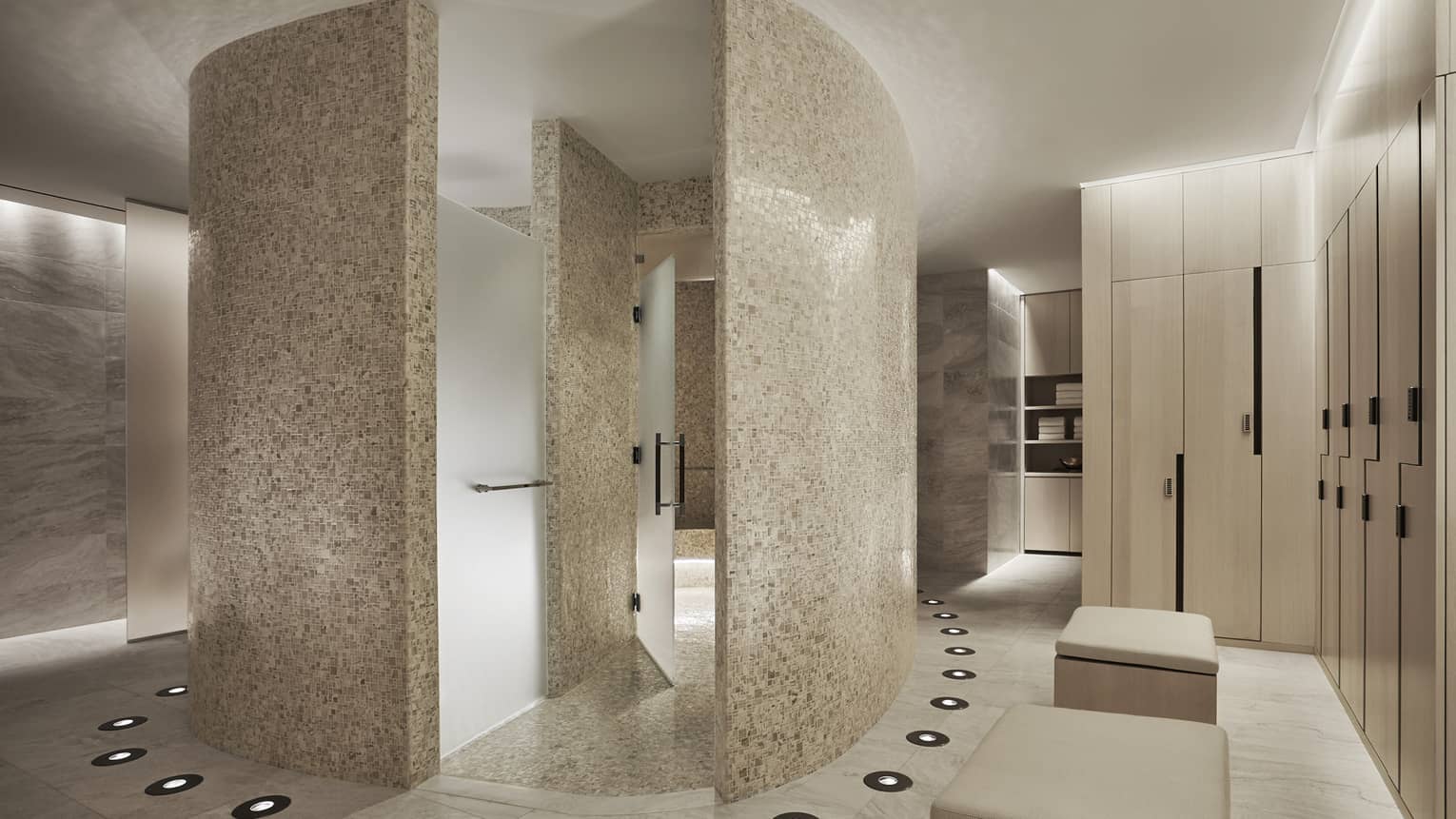Curved white stone walls in Spa locker room, wood lockers 