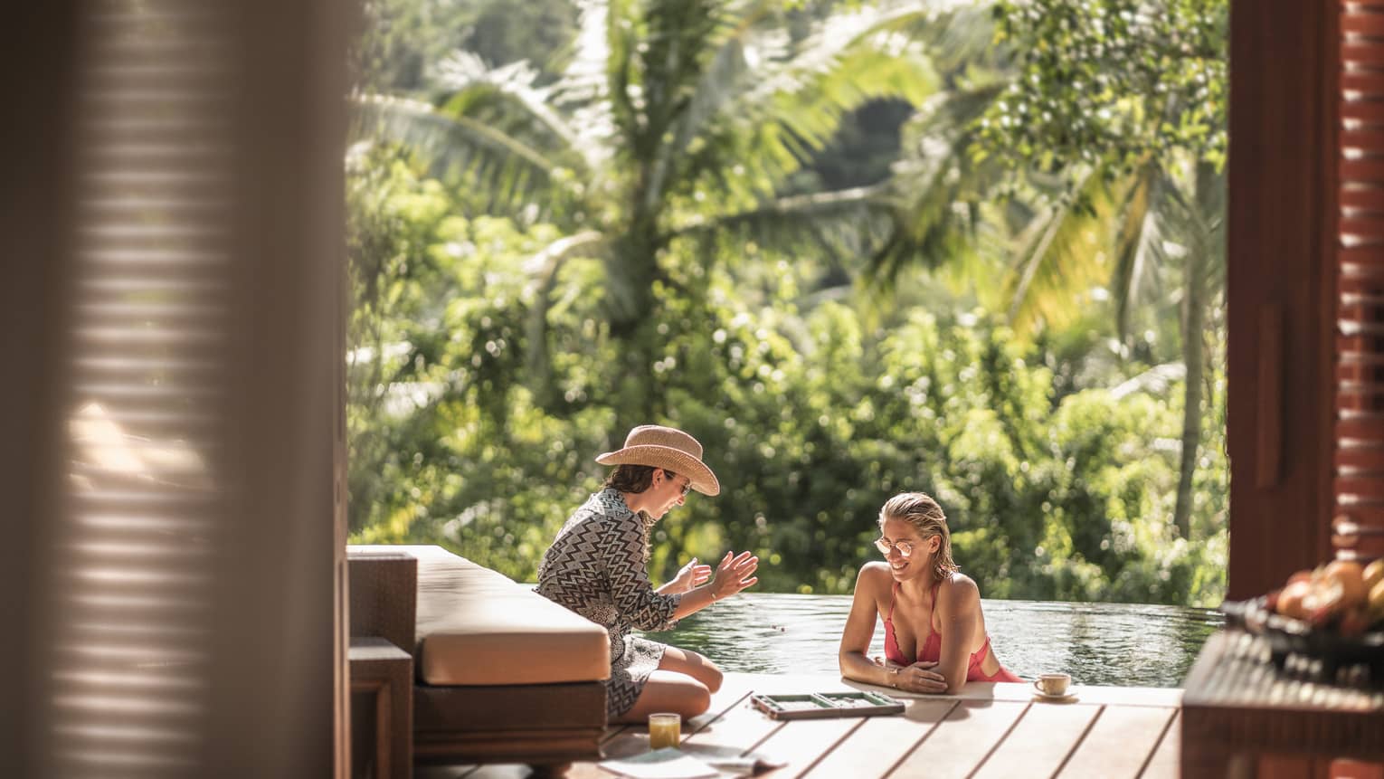 Two guests relaxing and conversing in an outdoor pool in Bali