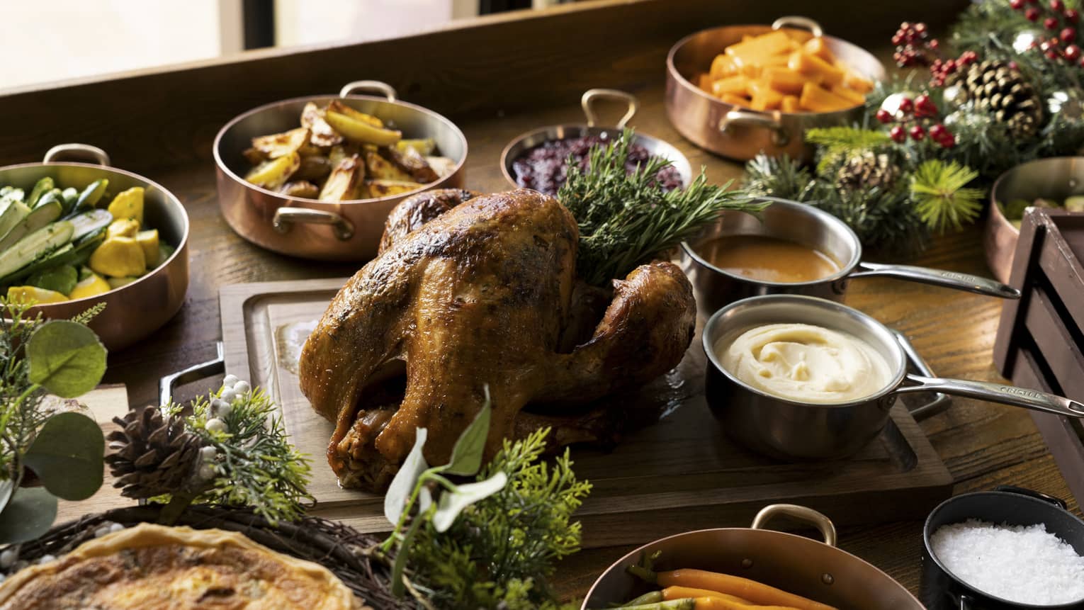 A festive holiday table with turkey, vegetables and other food
