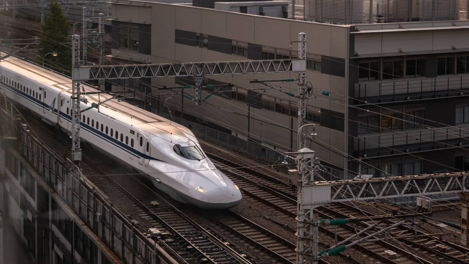 Shinkansen bullet train arrives at the station at sunset