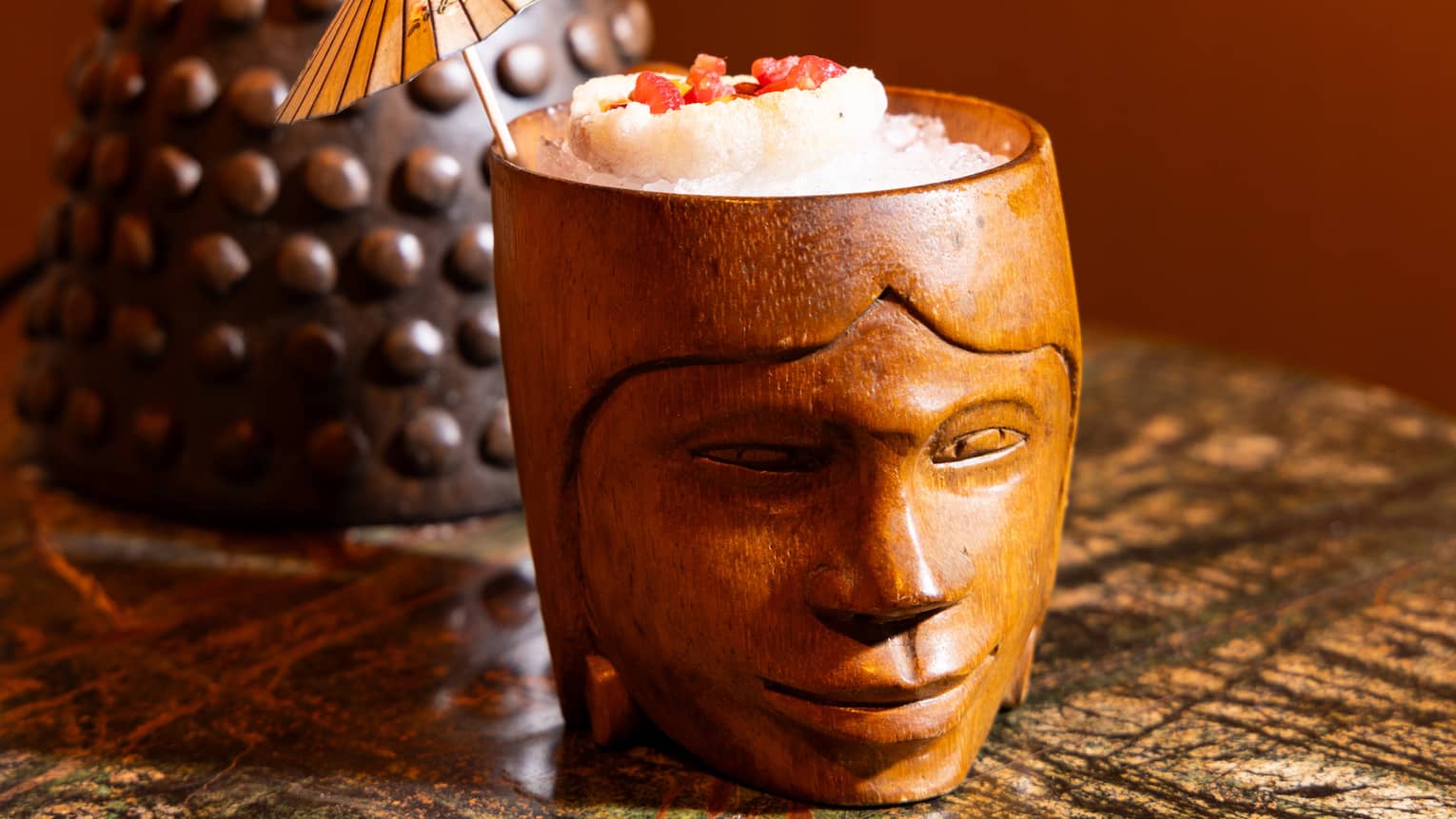 A tiki glass by a lamp.