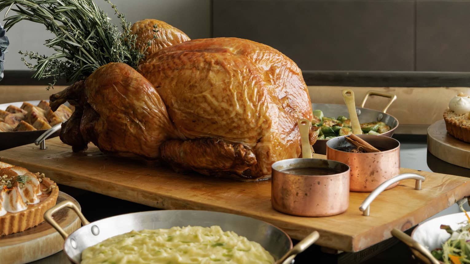 A whole roast turkey and sides set out on a dining table