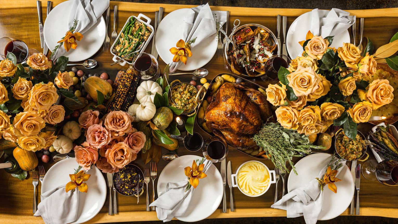 Overhead view of rectangular live-edge wooden table filled with a holiday feast