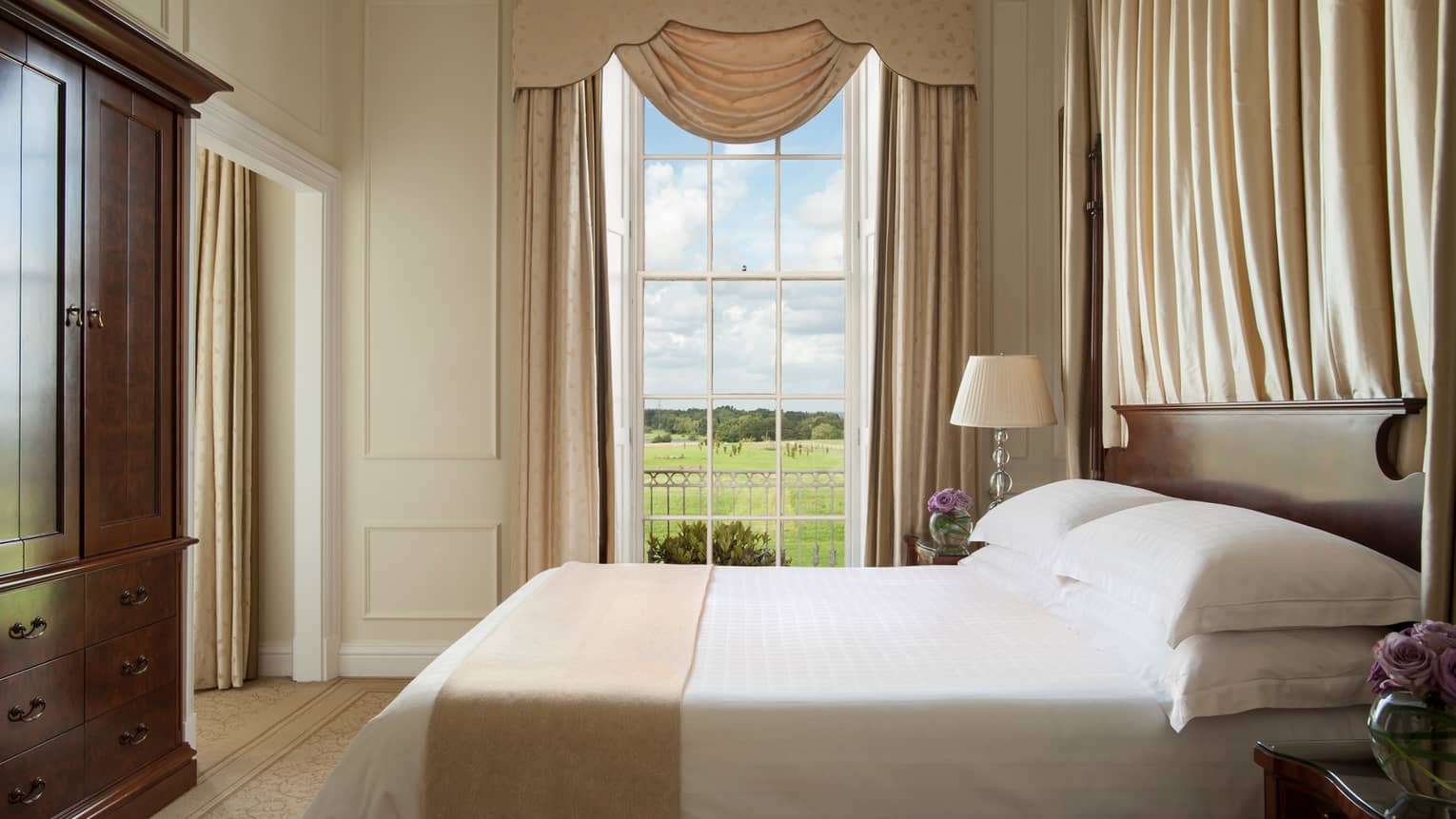 William Godson Suite tall window with canopy, bed by large wood wardrobe