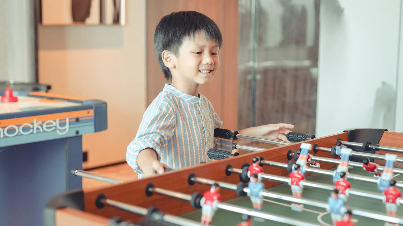 Young boy plays foosball