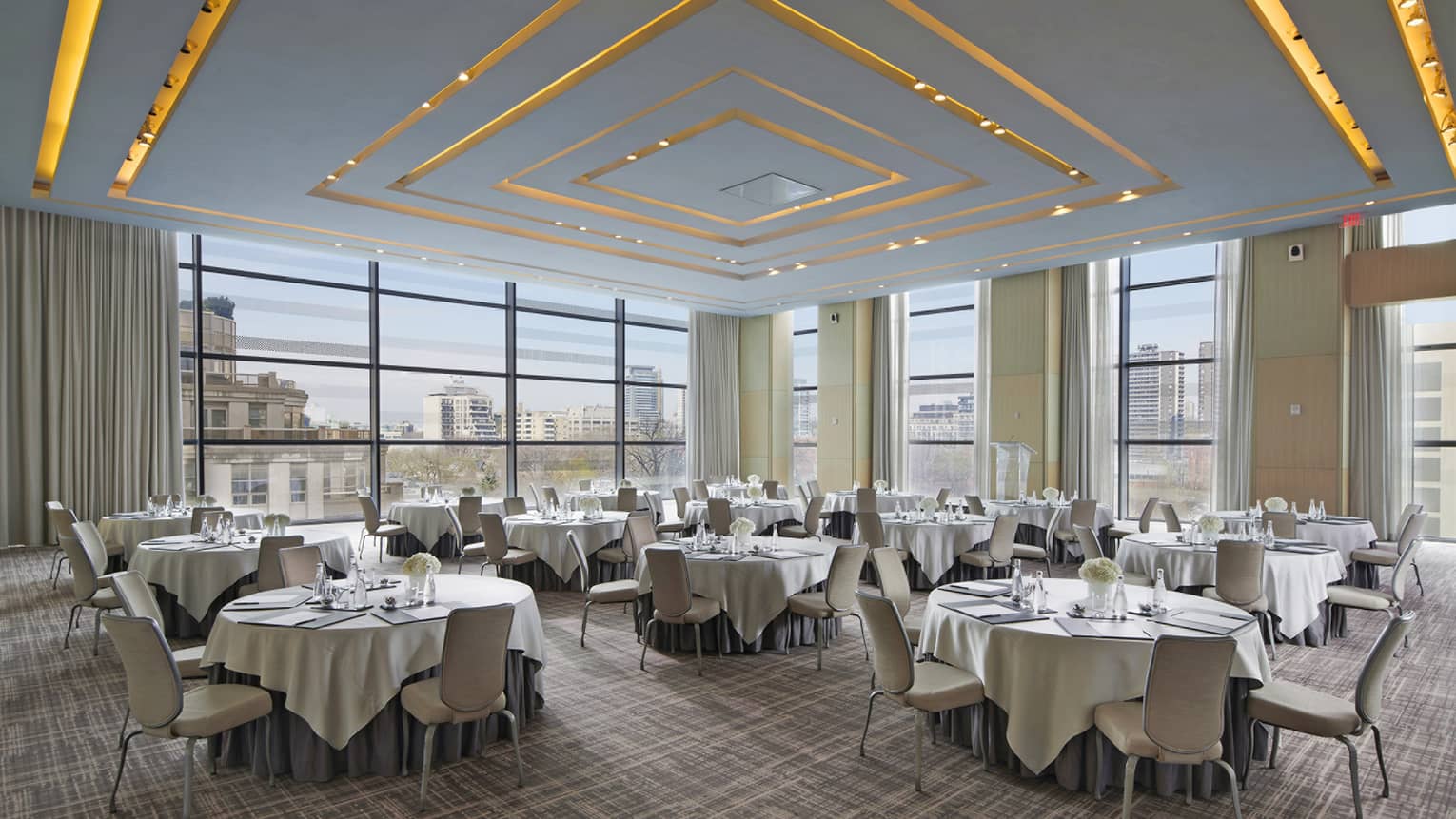 A series of circular tables adorned with white linen table cloths.