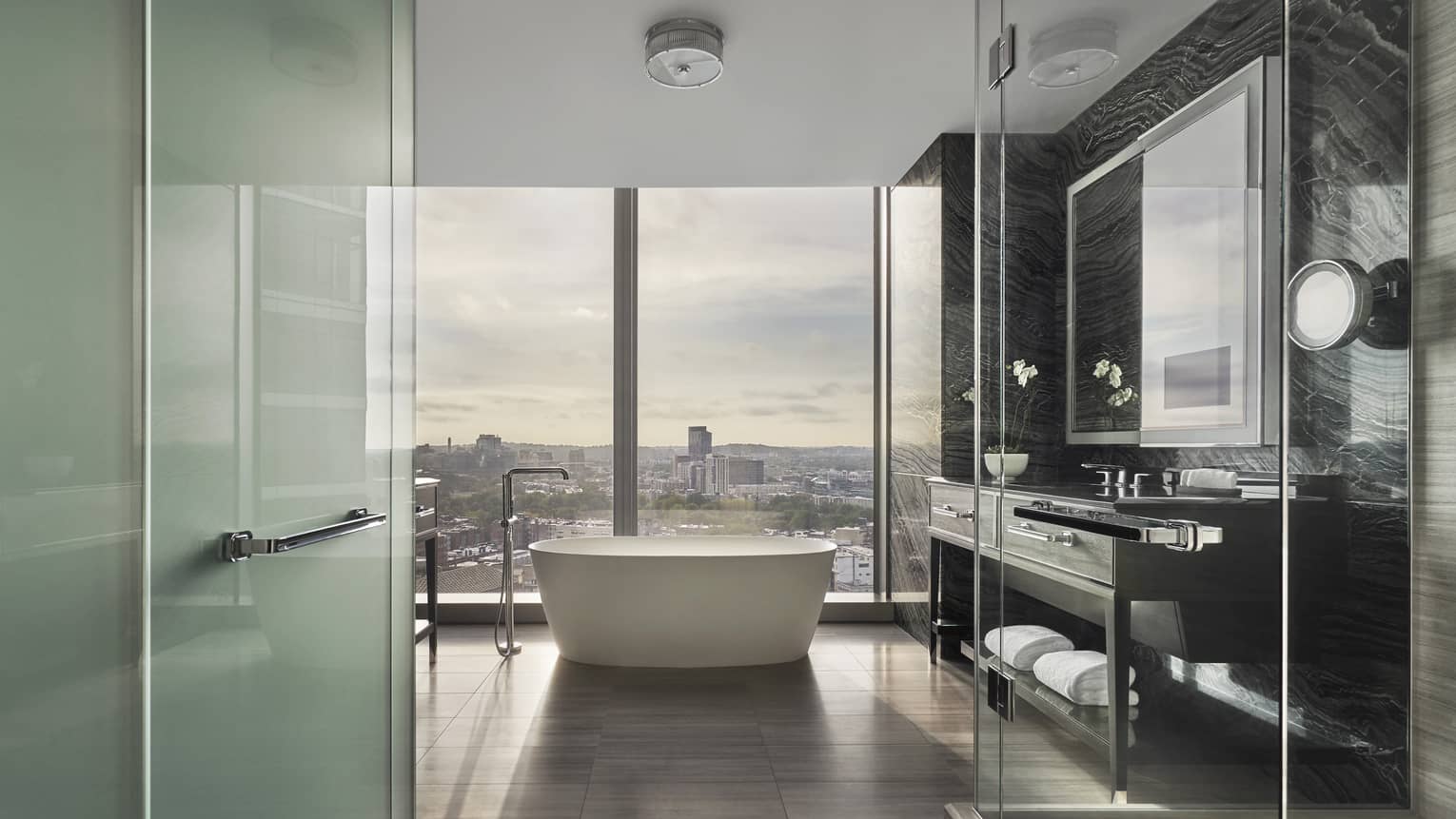 Corner Suite bathroom with freestanding tub by floor to ceiling window