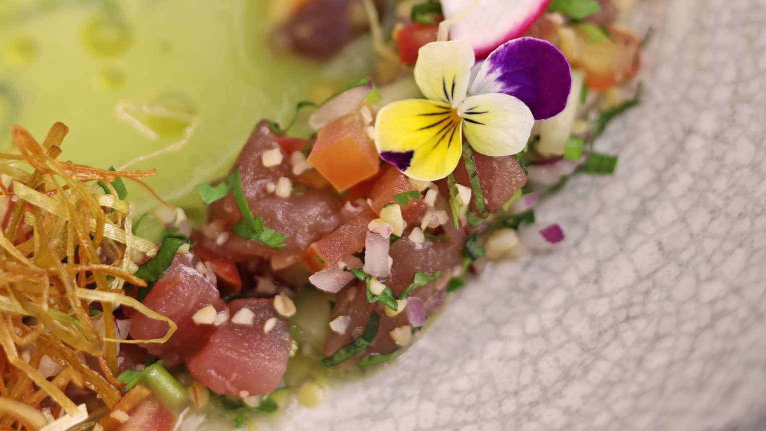 Fresh tuna tartare mixed with bulgur, cucumber, tomato and sweet corn, served with fresh herbs and green gazpacho