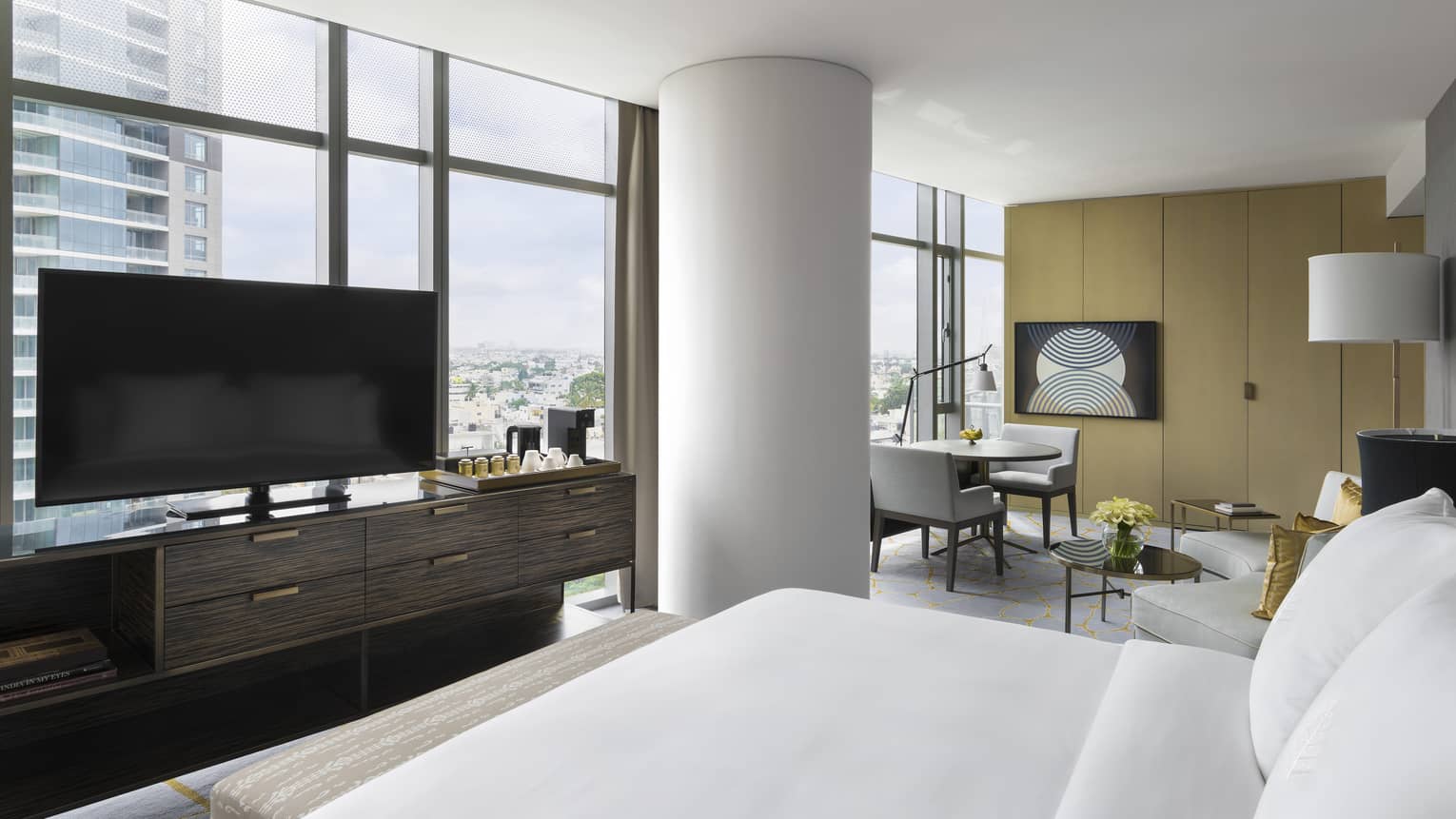Premier Room with white bed facing large flat-screen TV on console, and floor-to-ceiling windows with city views