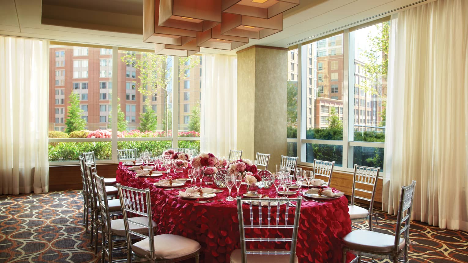 Verona room, round private dining table with red ruffled linen, bright corner windows