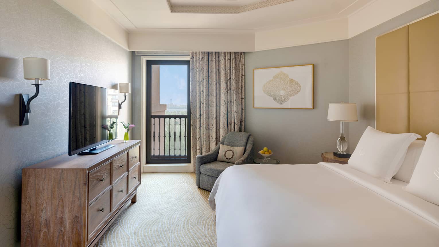Bedroom with king bed, white sheets, dresser and TV