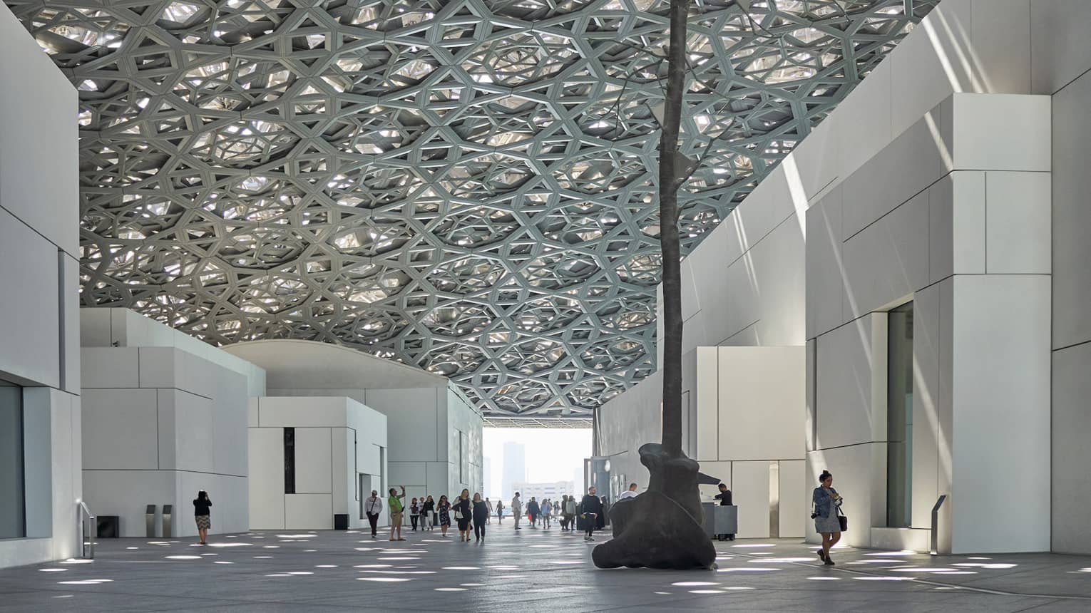 A large sculpture inside of a white stone building.