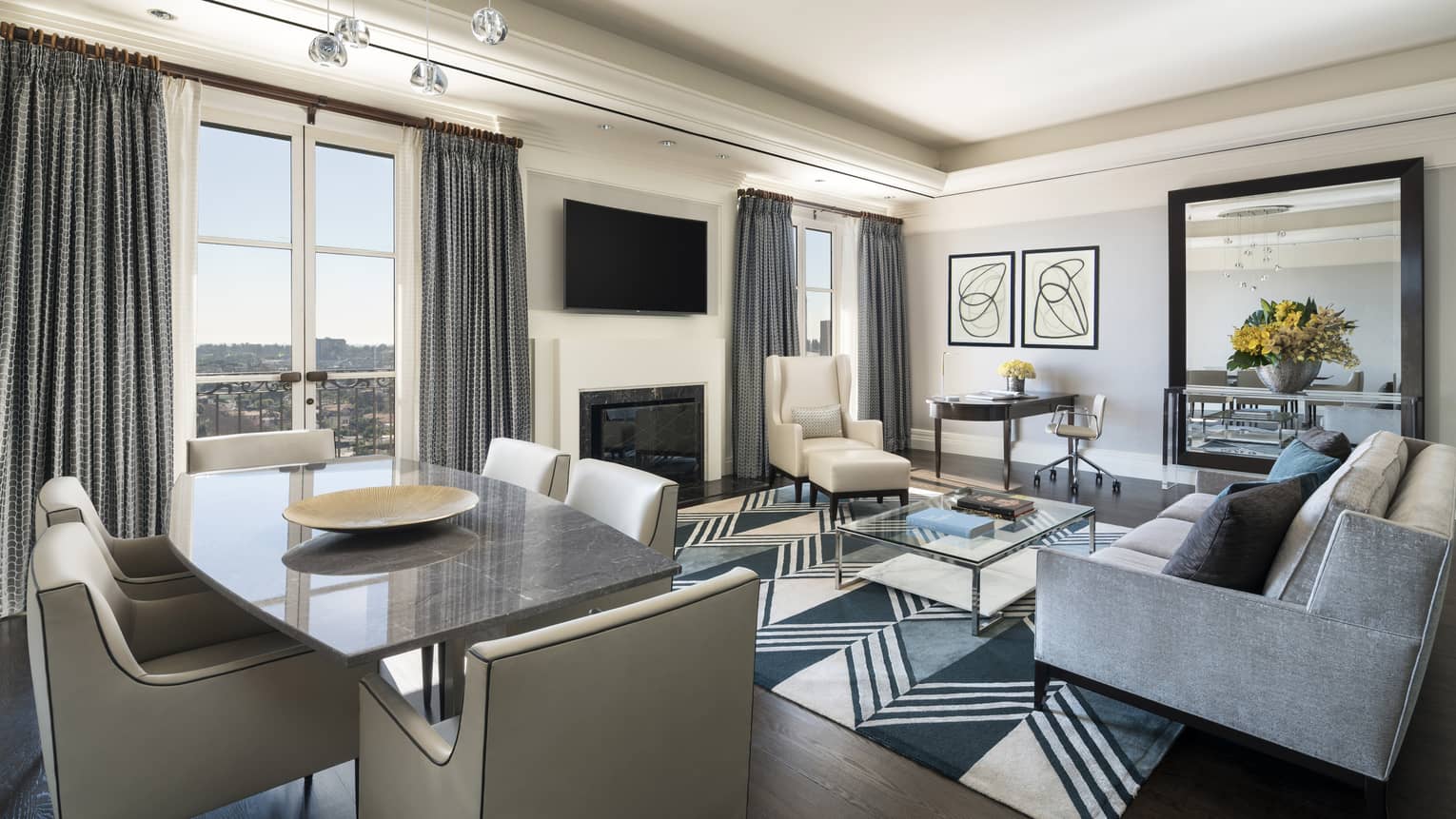Ambassador Suite modern dining table, chairs, grey sofa by glass table, white armchair, TV
