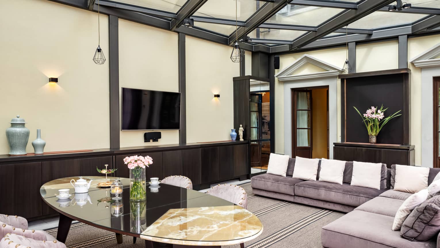 Glass-ceilinged living and dining room, with light-purple velvet sofa