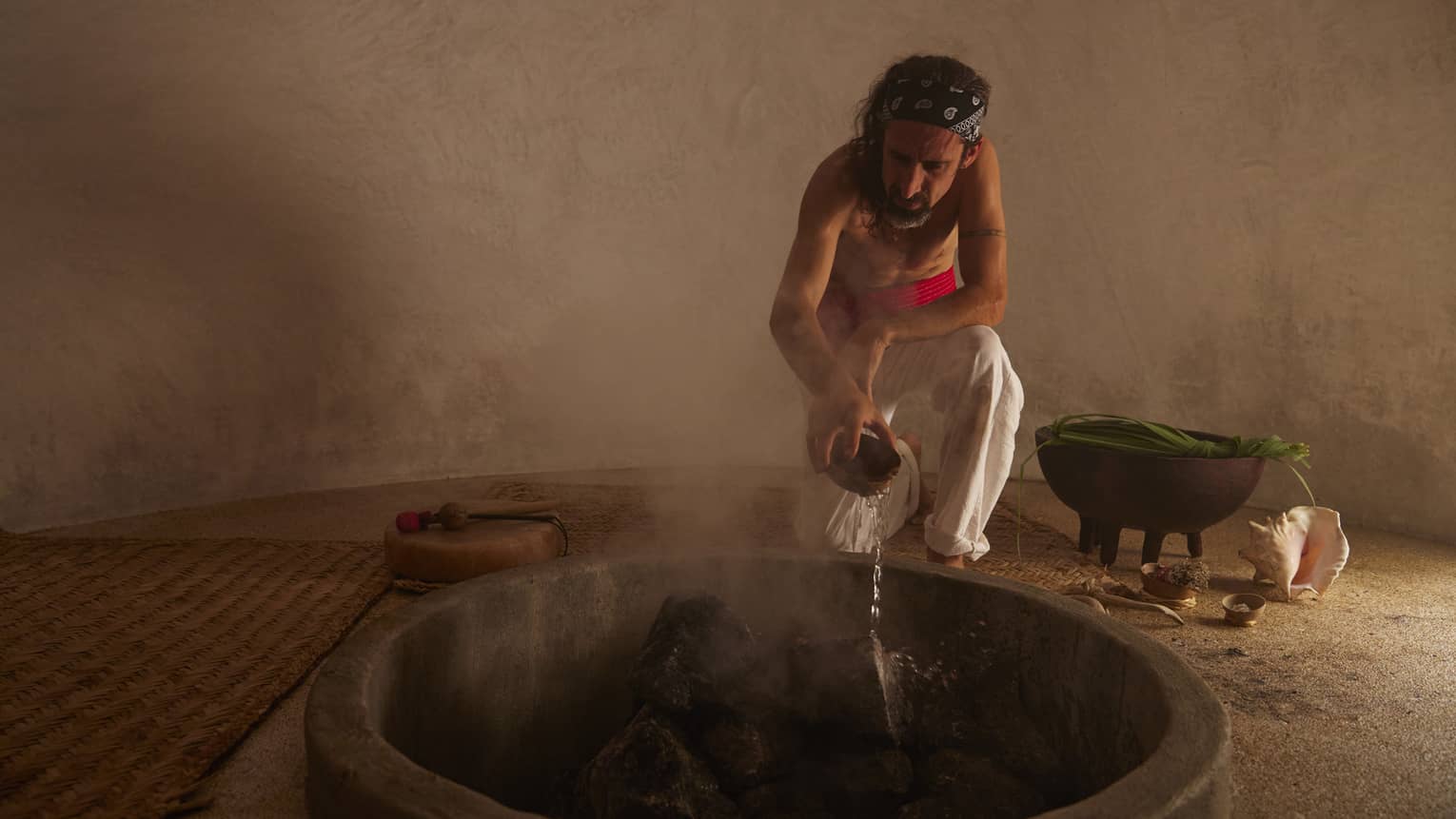 Man tends to a fire in a traditional temezcal or "house of heat"