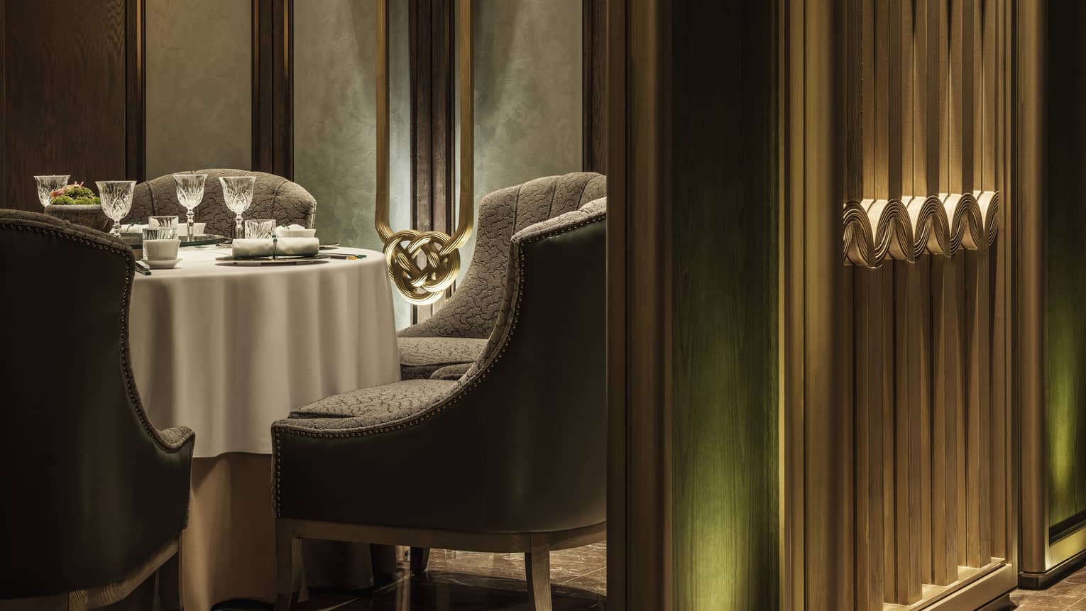 Yu Yuan close-up of plush dining chairs around round table with white cloth