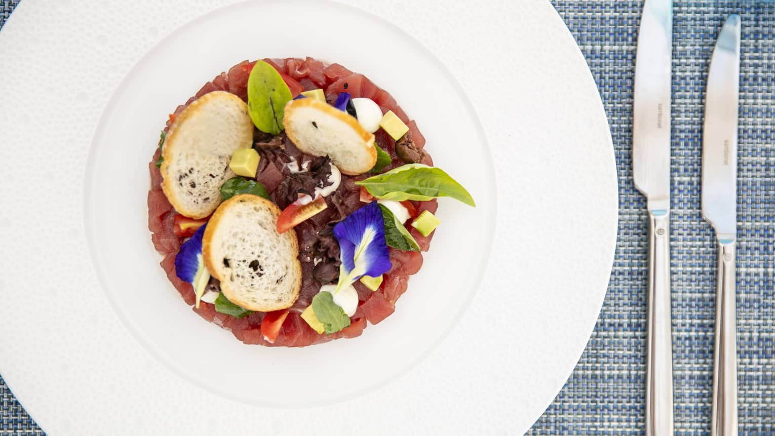 an aerial view of a vegetable dish with small bread rounds 
