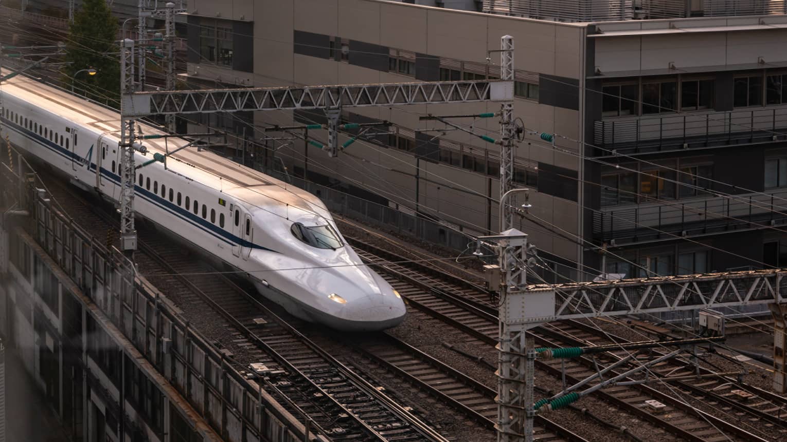 Shinkansen bullet train arrives at the station at sunset