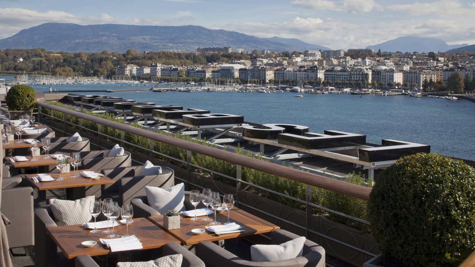 Dining tables along bright Izumi Terrace overlooking water 