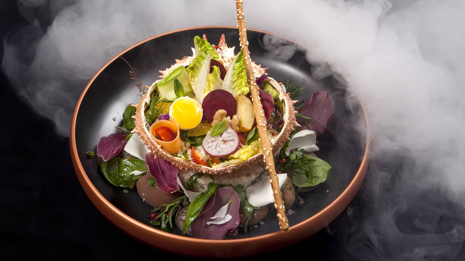 Gourmet salad with root vegetables, boiled eggs, breadstick in bowl surrounded by steam