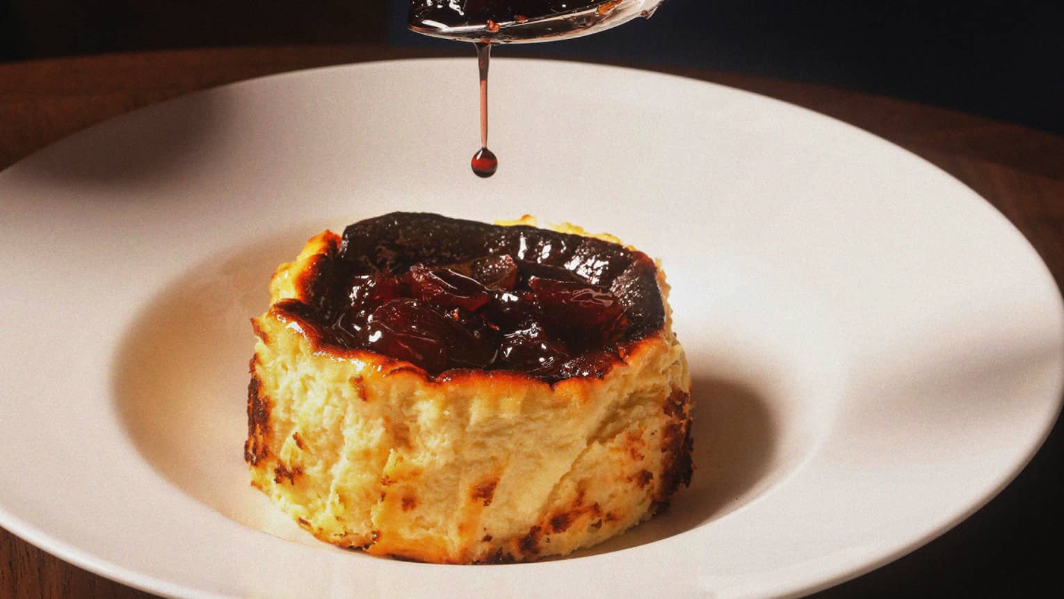 A cheesecake on a white plate with cherries