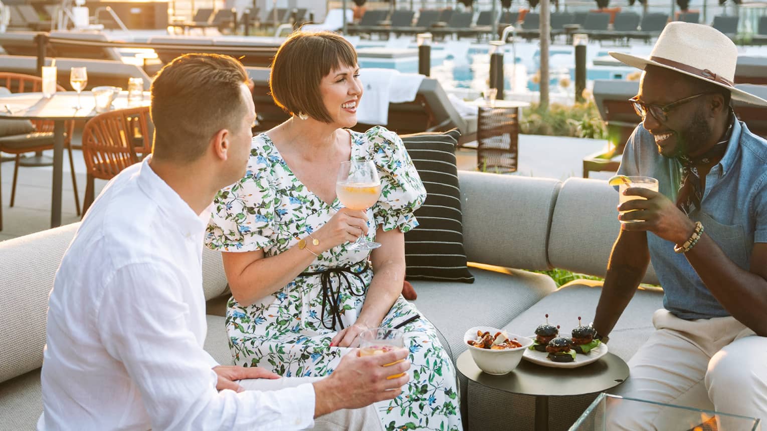 Three guests on a rooftop terrace enjoying a meal.