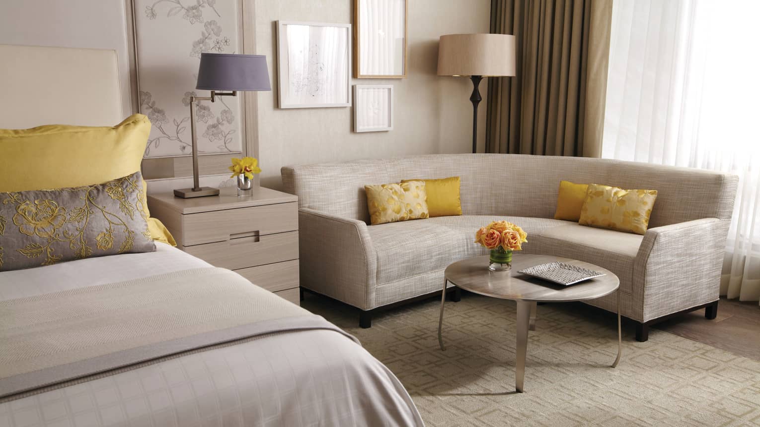 Yorkville Premier Room curved white sofa by bed, yellow accent pillows, yellow roses on table