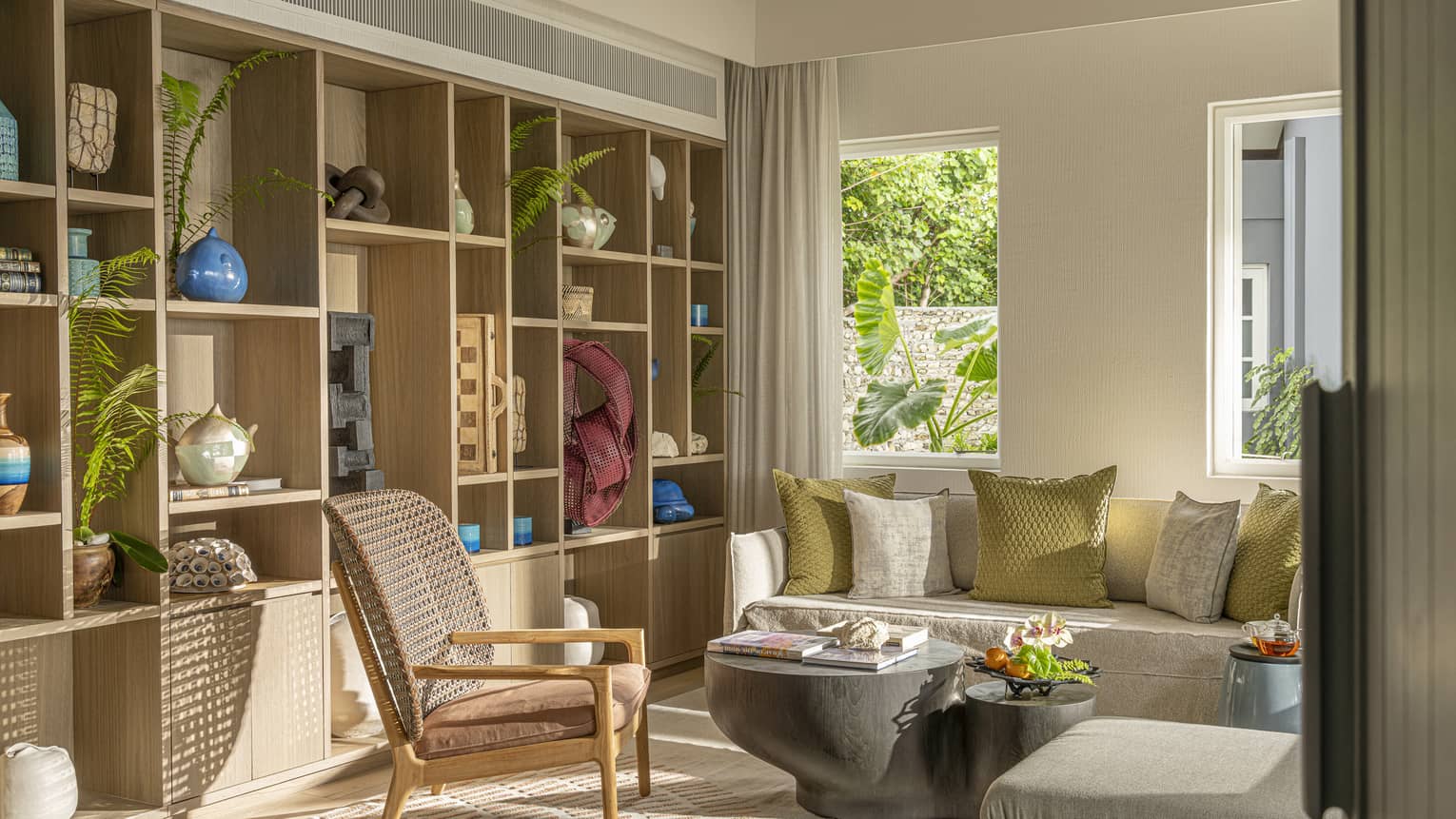 Library room in a luxury resort estate, featuring a sofa, chair and wall of shelves
